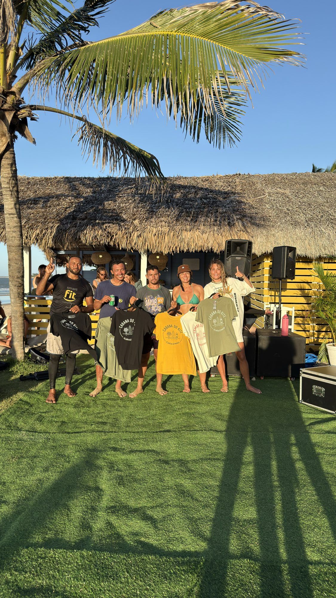 Un groupe d'amis montre des t-shirts imprimés de la Cabana do Kite.