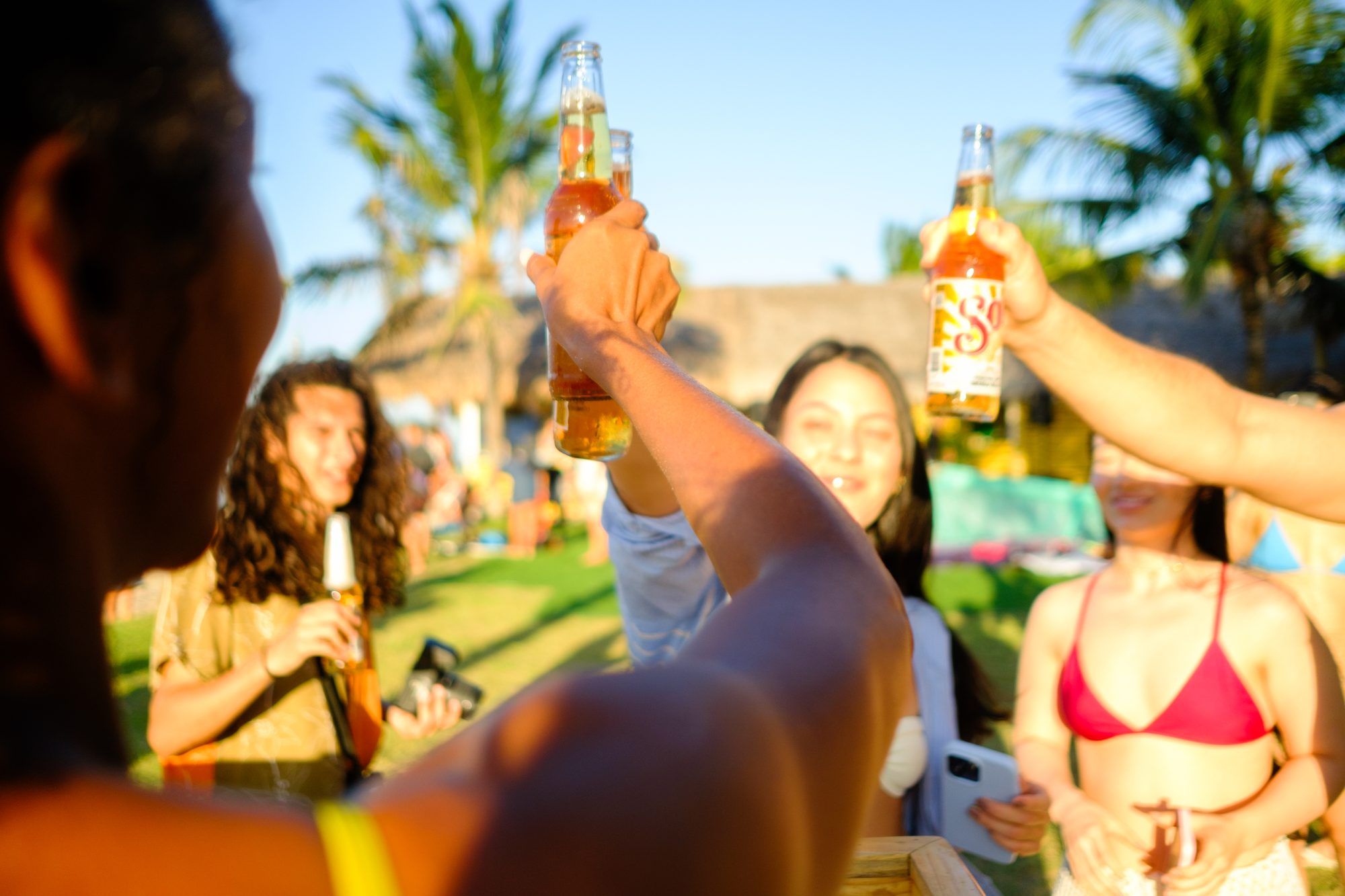 Un grupo de amigos brinda con cervezas al atardecer.