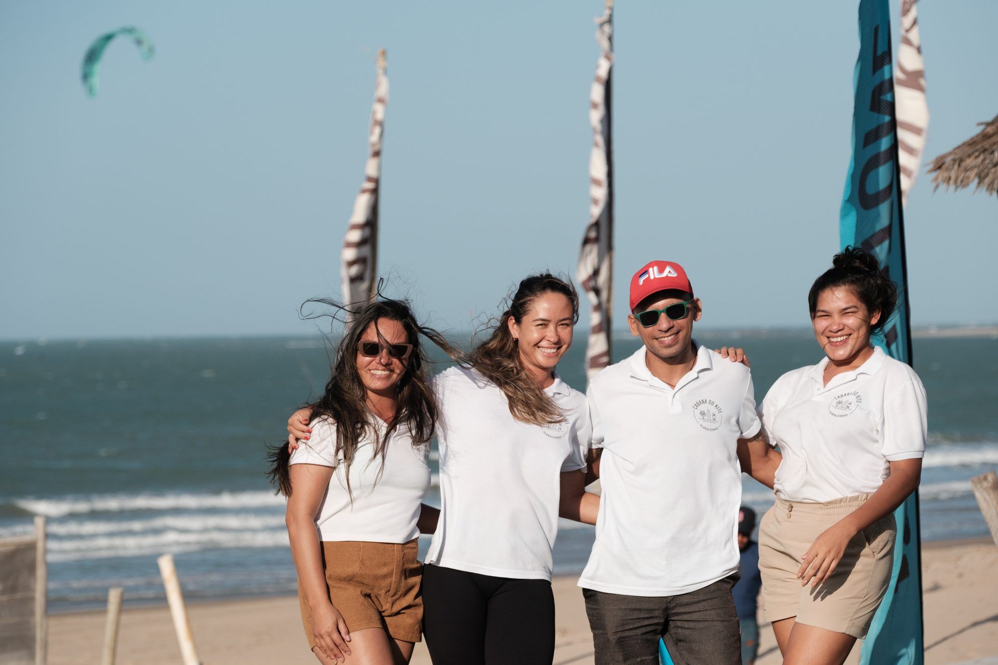 Integrantes del equipo de Cabana do Kite posan sonriendo en la playa.